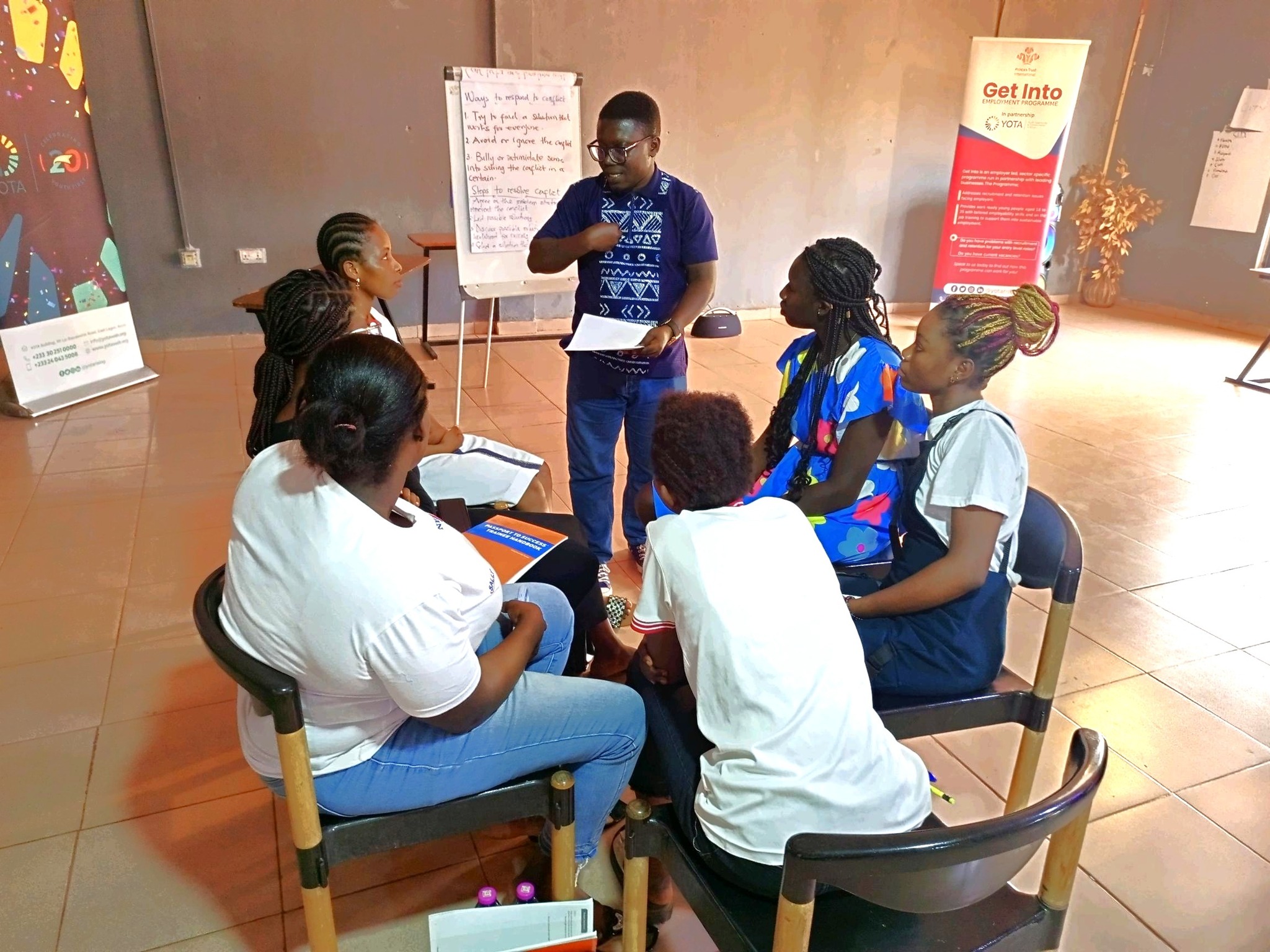 A session trainer giving some explanations to the participants in a group discussion